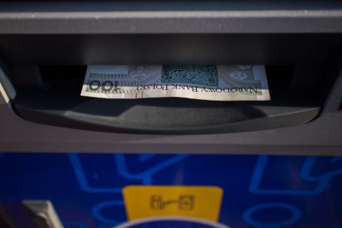 wygląd bankomatu z wydawanym banknotem