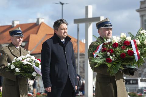 Marcin Wiącak stoi za oałnierzem trzymającym wieniec BRPO