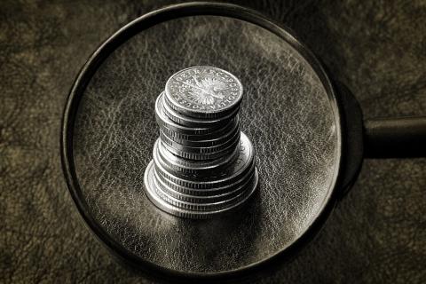 Stos monet widoczny przez szkło powiększające