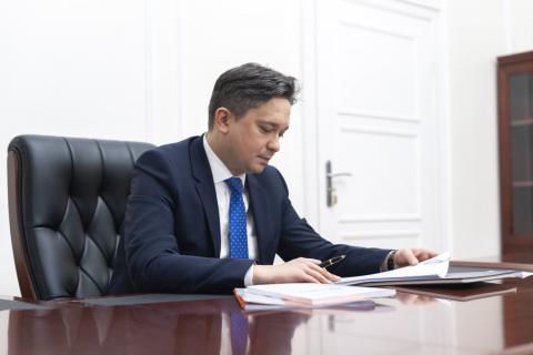 RPO Marcin Wiącek siedzący przy biurku i podpisujący dokumenty