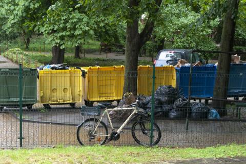 Rząd kilku kontenerów do segregacji odpadów stojących na ulicy