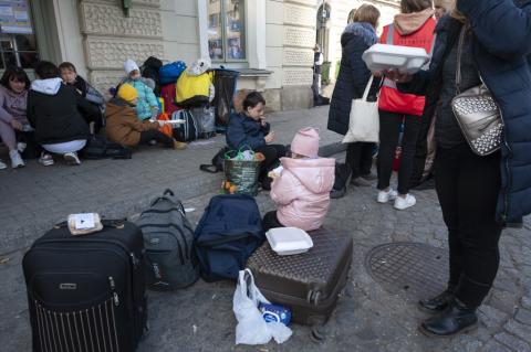 uchodźcy z Ukrainy ze swymi rzeczami na dworcu w Polsce