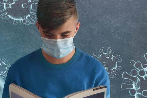 uczeń w masce z podręcznikiem na tle grafiki z wirusami 