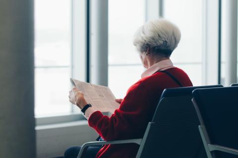 Starsza kobieta czytająca gazetę