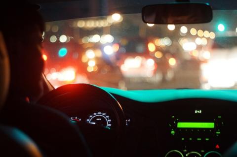 widok samochodu jadącego nocą po mieście z tylnego miejsca