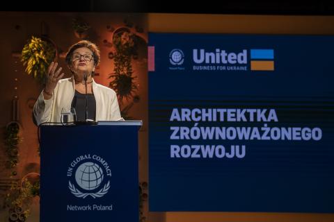 ZRPO Hanna Machińska stoi za mównicą i wygłasza przemówienie, w tle wyświetlacz z napisem "Architekta Zrównoważonego Rozwoju"