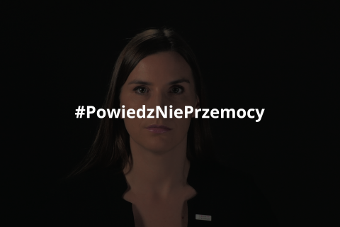Magdalena Sobkowiak stojąca na czarnym tle i spoglądająca w obiektyw. Na obraz nałożony jest hashtag "Powiedz Nie Przemocy"