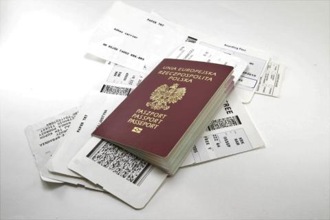 polski paszport na tle kart pokładowych do samolotu 