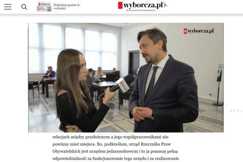 Zrzut ekranu ze strony wyborcza.pl ze zdjęciem, na którym RPO Marcin Wiącek odpowiada na pytania dziennikarki