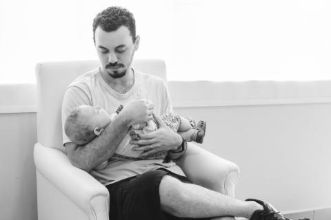Siedzący mężczyzna trzyma małe dziecko na rękach