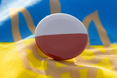 Przypinka z polską flagą leżąca na fladze Ukrainy