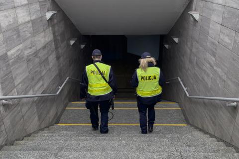 Dwoje policjantów schodzi po schodach do przejścia podziemnego