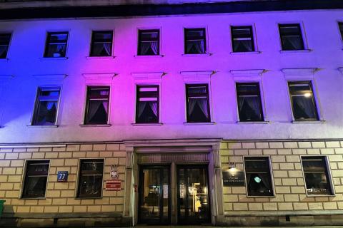 Elewacja budynku z tabliczką "Rzecznik Praw Obywatelskich" podświetlona na kolor niebieski i różowy