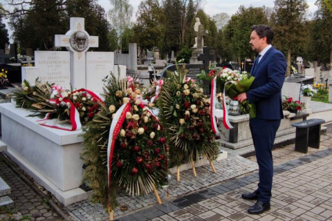 RPO Marcin Wiącek stoi z wiązanką kwiatów przed grobem Janusza Kochanowskiego
