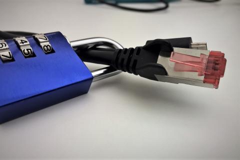 Kłódka zamknięta na kablu ethernet do podłączania komputera do sieci