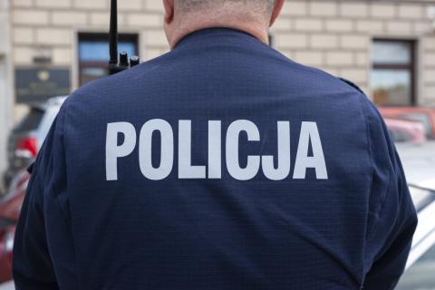 Policjant w mundurze z napisem POLICJA na plecach