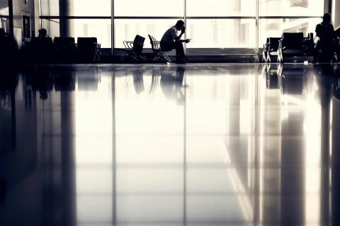 Siedząca osoba czeka na sali odlotów na lotnisku