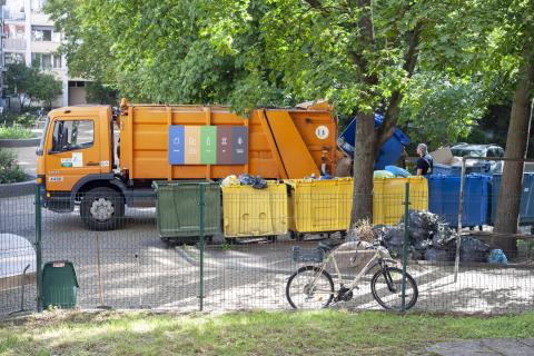 Śmieciarka zabiera śmieci wrzucone do kontenerów