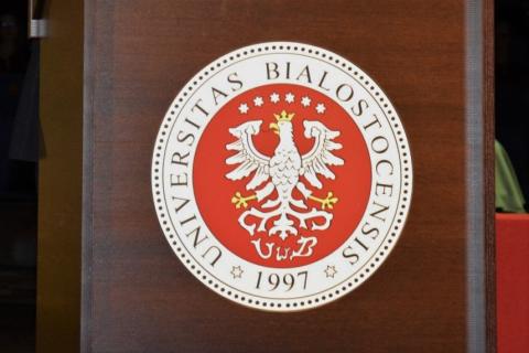 Herb Uniwersytetu w Białymstoku przedstawiający białego orła na czerwonym tle z okalającym napisem "Universitas Bialostocensis 1997")