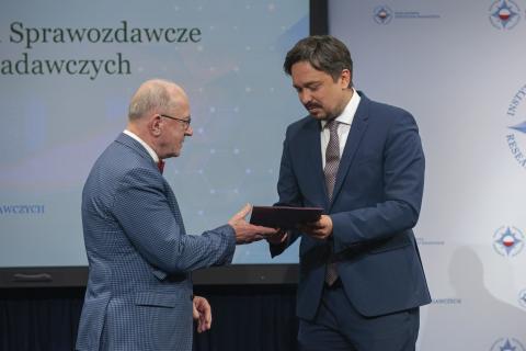 RPO Marcin Wiącek wręcza laureatowi nagrodę w skórzanej oprawie