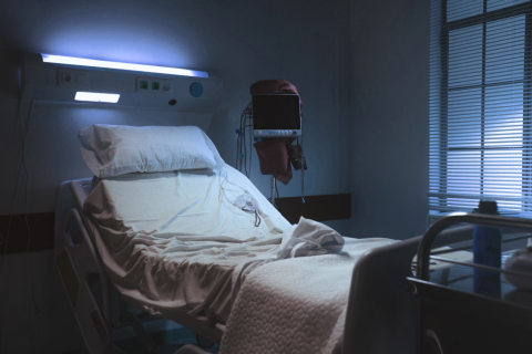 puste łóżko w ciemnej  sali szpitalnej