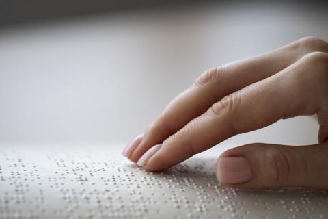 palce kobiety na piśmie w języku braille'a
