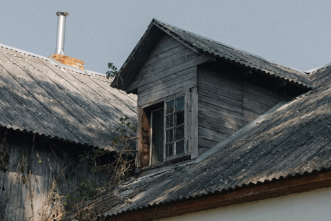 dach starego domu częściowo z drewna a częściowo z eternitu  