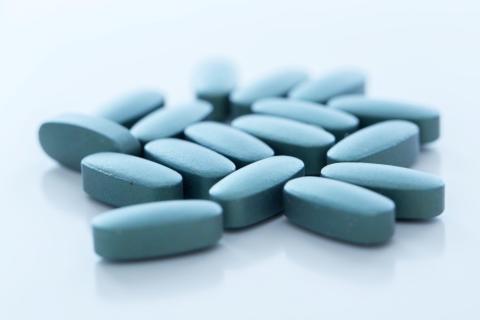 niebieskie tabletki leżą na białej powierzchni 