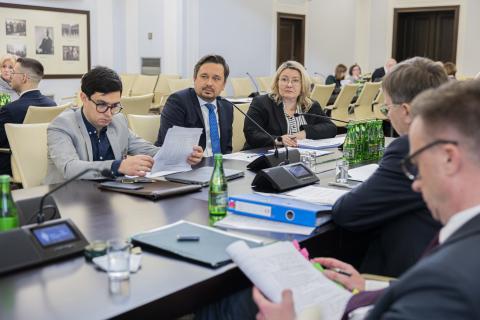 Michał Szwast, Marcin Wiącek i Ilona Bogusławska siedzą przy stole w sali Komisji. 