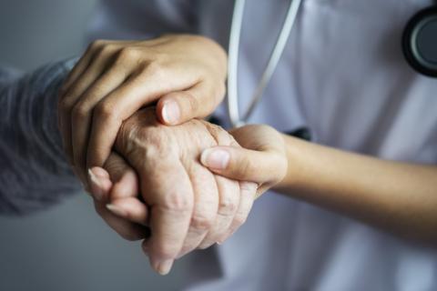 lekarka trzyma dłoń starszej osoby 