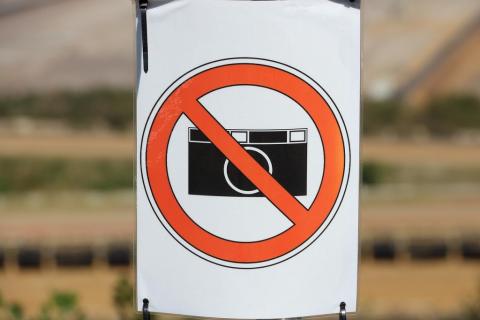 stylizowany znak zakazu z przekreślonym czerwoną barwą aparatem fotograficznym  