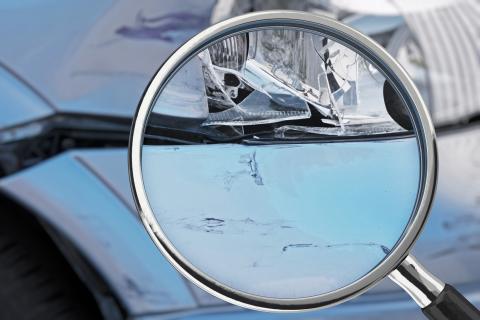 Szkło powiększające skierowane na samochód uszkodzony w stłuczce