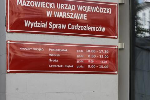 Czerwona tablica z białymi napisami - Mazowiecki Urząd Wojewódzki w Warszawie, Wydział Spraw Cudzoziemców