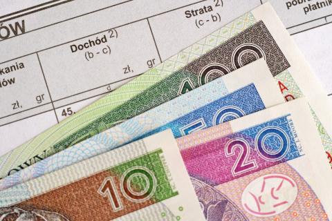 Banknoty leżące na formularzu podatkowym