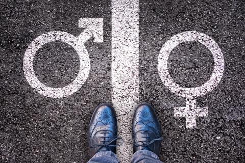 Stopy osoby ustawione na linii pomiędzy symbolami płci żeńskiej i męskiej