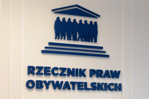 Granatowy napis na ścianie "Rzecznik Praw Obywatelskich" i logo RPO