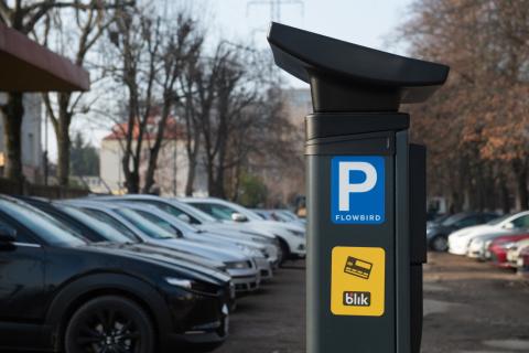 Parkomat do pobierania opłat za parkowanie stojący przy ulicy, wzdłuż której parkują samochody