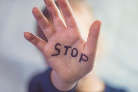 napis "Stop" napisany na wyciagniętej dłoni