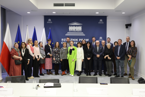 osoby w sali pozują do zdjęcia na stojąco  