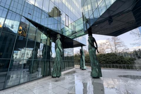 rzeźby figur kobiet przy szklanych ścianach budynku  