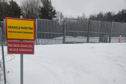płot graniczny przed nim tablica z tekstem granica państwa przekraczanie zabronione