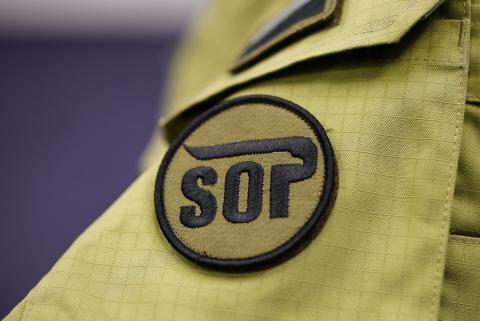 naszywka z literami SOP na jasnozielonym ubiorze 