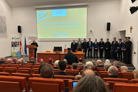 osoby siedzą w sali jedna przemawia