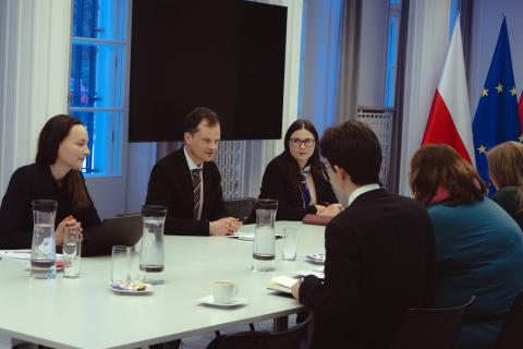 Sześć osób rozmawia przy stole konferencyjnym