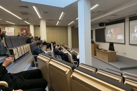 Sala wykładowa na uczelni z ludźmi słuchającymi wystąpienia