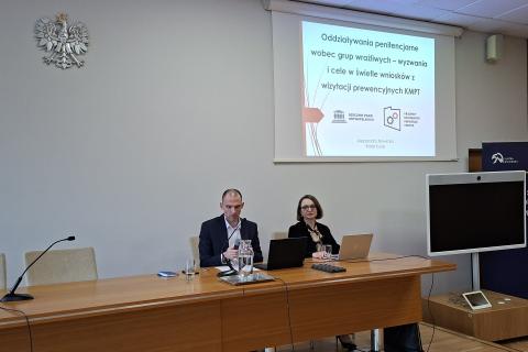 Dwie osoby siedzą w sali 