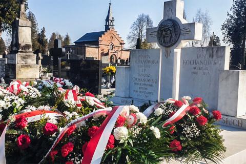 grób na cmentarzu w wieńcach i kwiatach 