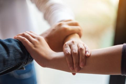 dwie osoby trzymają się za ręce