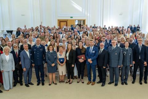 Kilkadziesiąt osób pozuje na stojąco do wspólnego zdjęcia