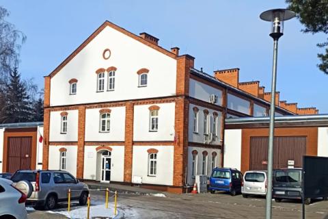 widok budynku obok którego stoi kilka samochodów  